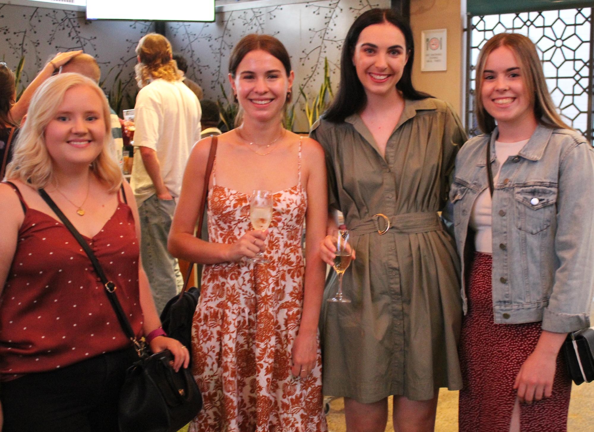 Group of young women at a Mercedes College alumni event holding drinks and smiling.